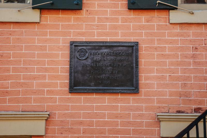 Historical plaque mounted on the exterior brick wall of the Petersen House in Washington, D.C