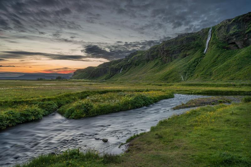 Coucher de soleil sur la rivière Seljalandsá par la cascade de Seljalandsfoss dans le sud-est de l''